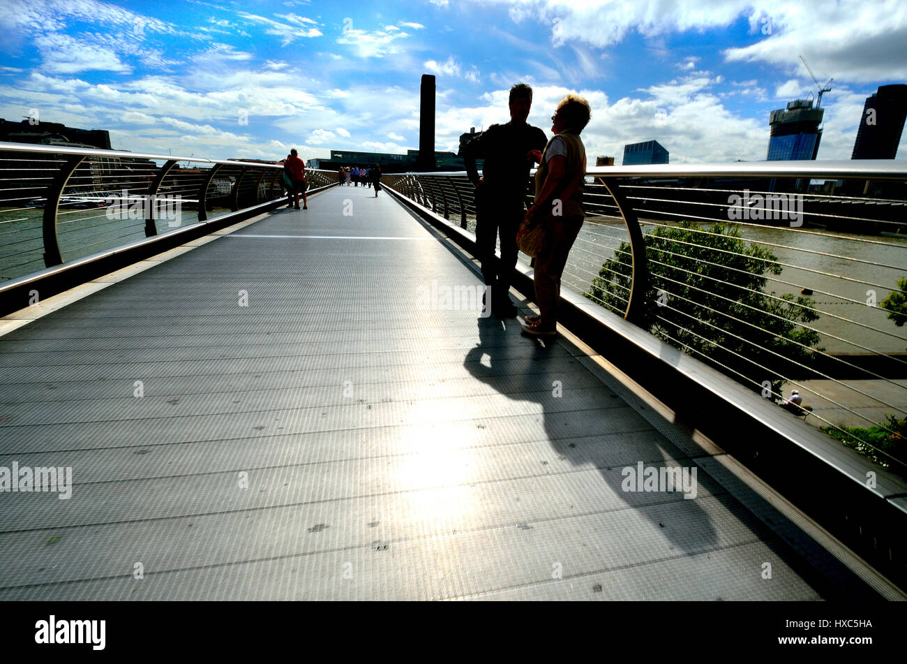 Londra, Inghilterra, Regno Unito. Due persone in sihouette parlando al Millenium Bridge Foto Stock