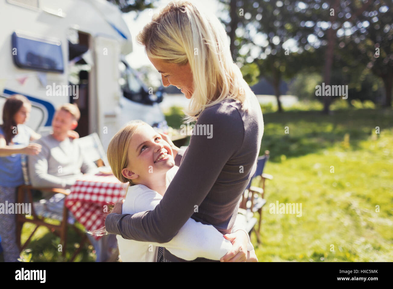 Affettuosa madre e figlia che abbraccia esternamente sunny motor home Foto Stock