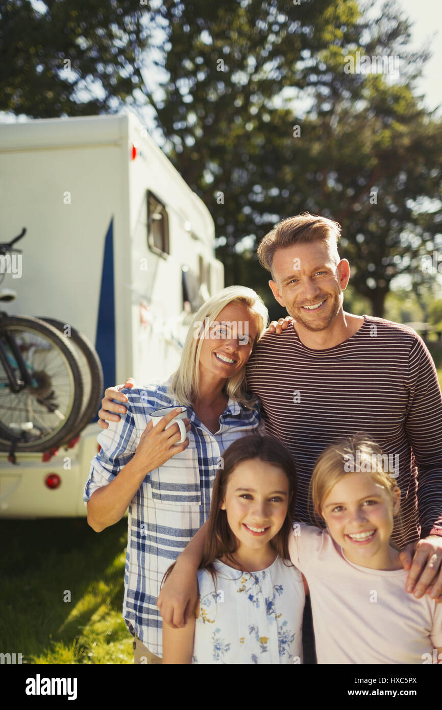 Ritratto affettuoso sorridente al di fuori della famiglia sunny motor home Foto Stock