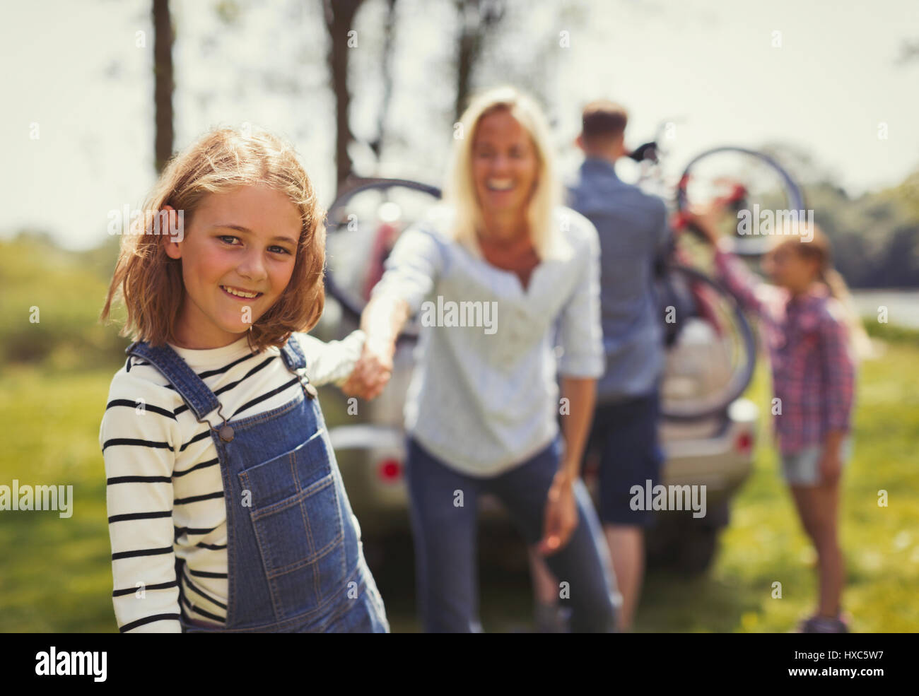 Ritratto sorridente madre e figlia per mano fuori dall'auto Foto Stock