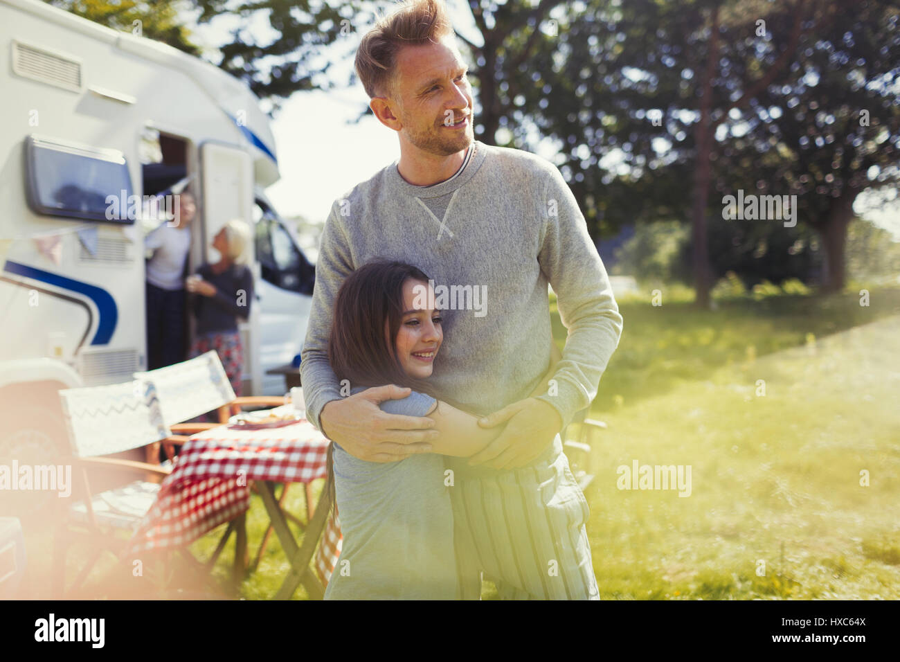 Padre affettuoso e la figlia che abbraccia esternamente sunny motor home Foto Stock