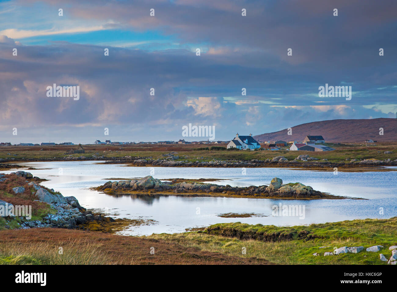 Tranquillo paesaggio nuvole sopra il lago e il villaggio di pescatori, Lochboisdale, Sud Uist, Ebridi Esterne Foto Stock