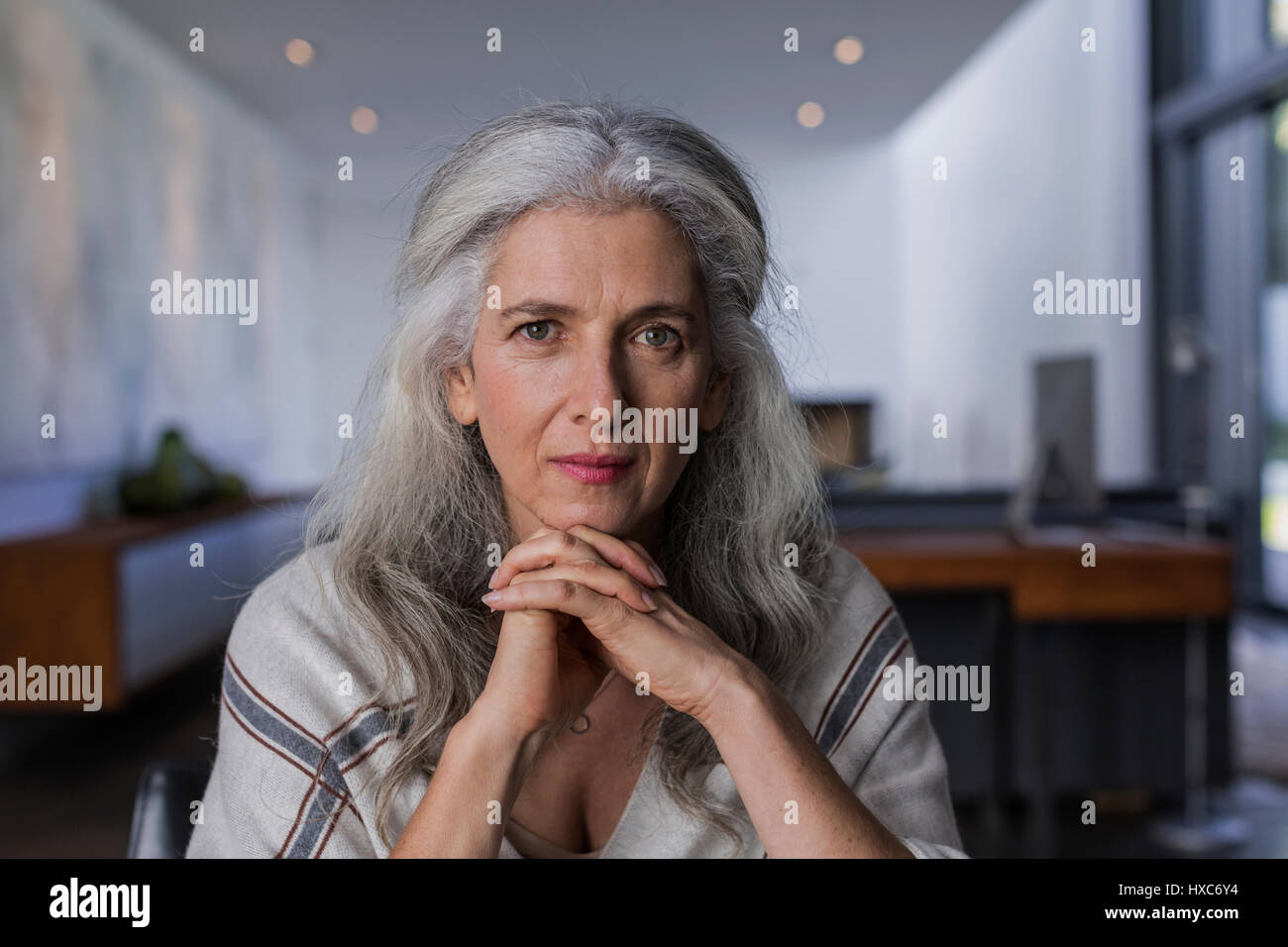 Ritratto fiducioso e grave di donna matura con lunghi capelli grigi Foto Stock