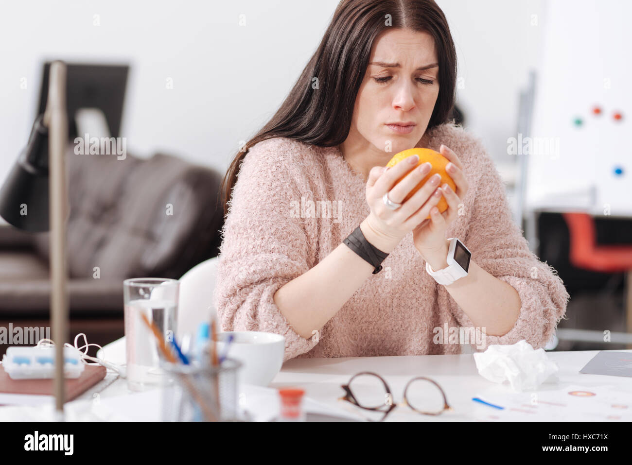 Femmina malato persona in possesso di big orange Foto Stock