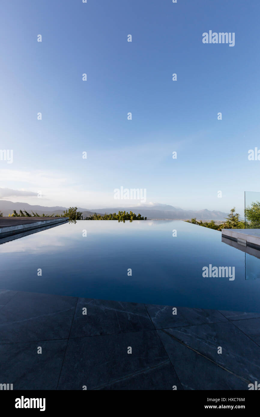 Lusso tranquillo Infinity piscina sotto il cielo blu Foto Stock