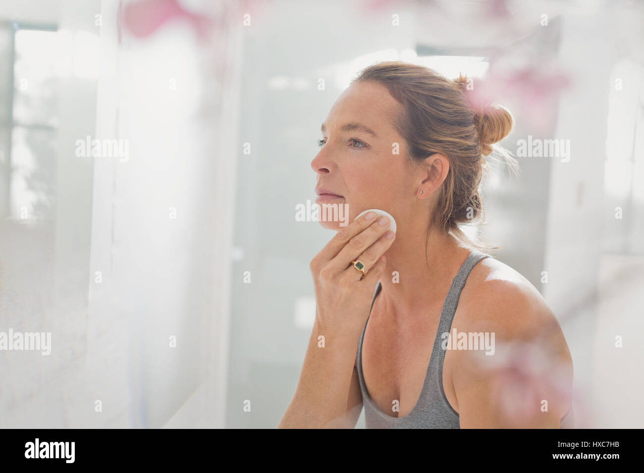 Donna matura applicare trucco nella Specchio bagno Foto Stock