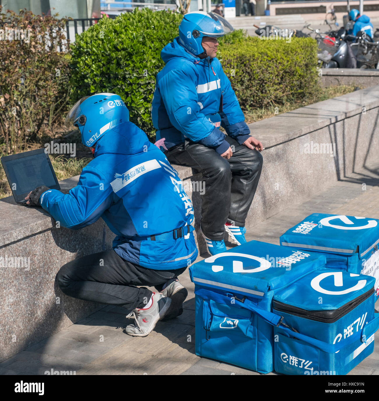 Un uomo di consegna utilizza il notebook per prendere-distribuzione fuori dalla strada a Pechino in Cina. 27-Mar-2017 Foto Stock