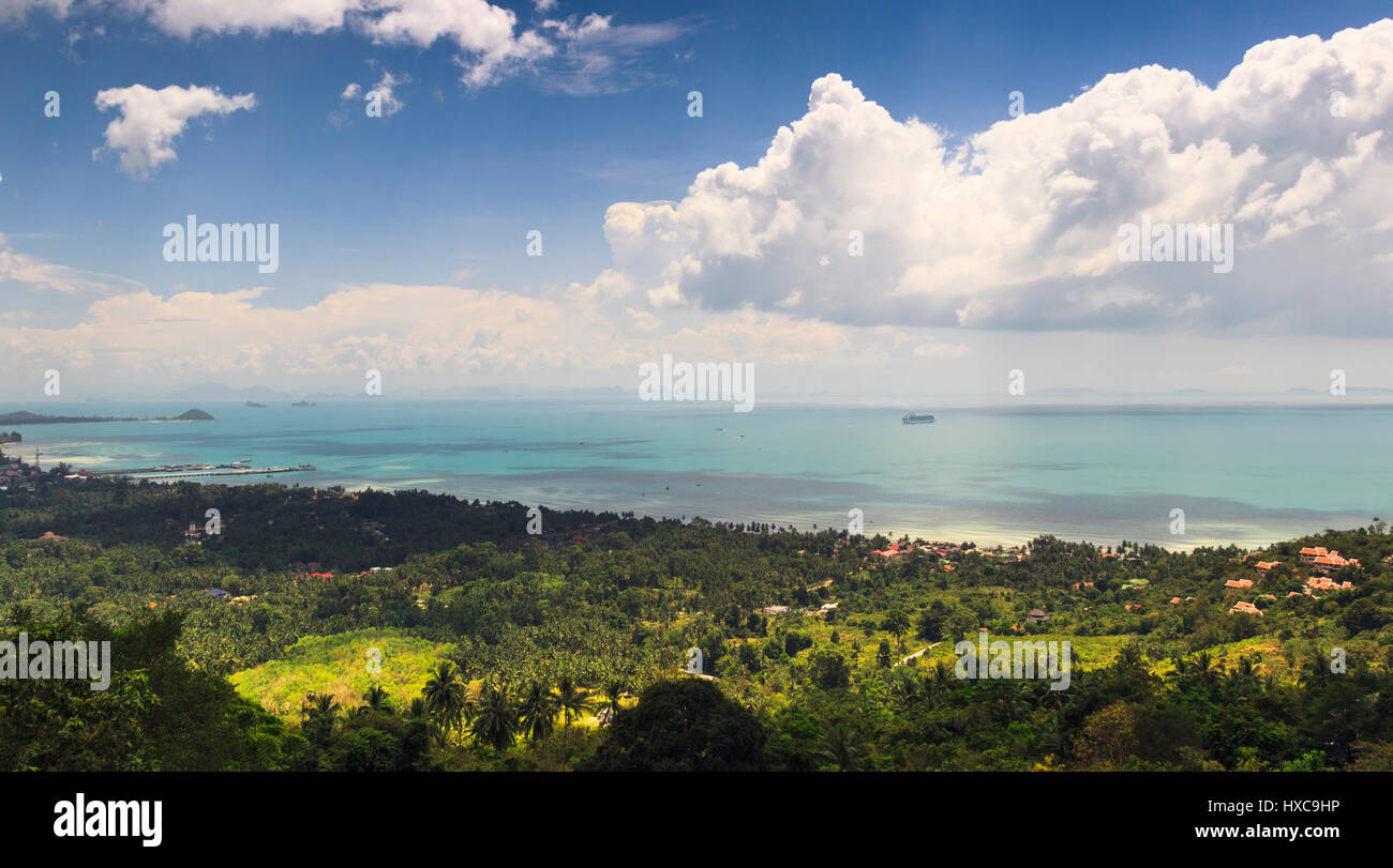 Seascape panoramico con la foresta tropicale valley, laguna con imbarcazione pier e piccolo villaggio. calma oceano e cielo nuvoloso. Koh Samui, Thailandia. antenna Foto Stock