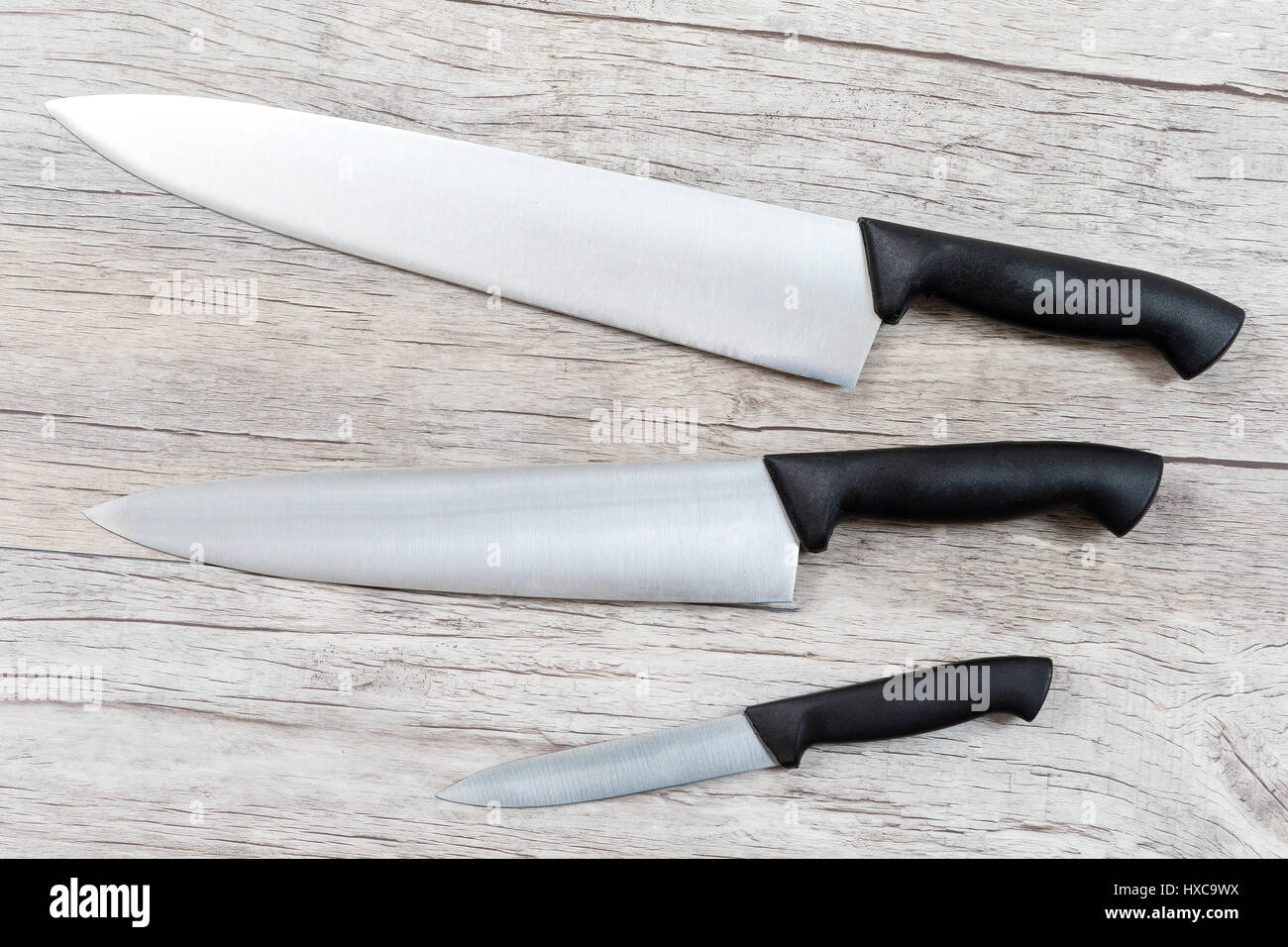 Set di coltelli isolati su vecchio bianco sullo sfondo di legno vista superiore Foto Stock