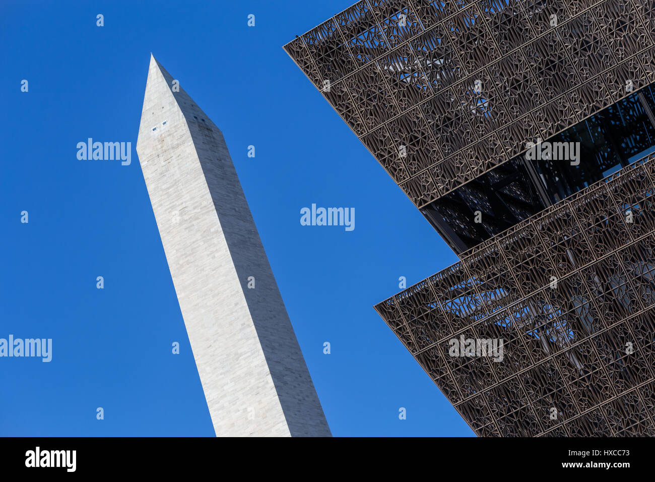 Il metallo angolare architettura del Museo Nazionale di afro-americano della storia e della cultura dei contrasti con il Monumento di Washington a Washington, DC Foto Stock