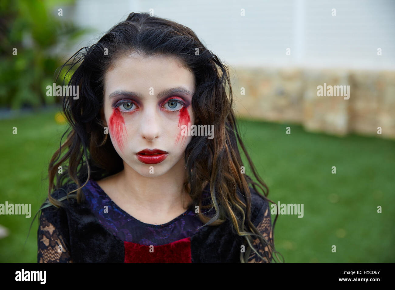 Halloween kid girl customer con sanguinosa trucco sul tappeto erboso cortile Foto Stock