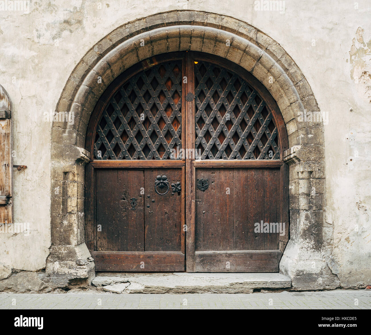 Bellissima medievale cancello in legno con arco in pietra nel vecchio edificio spiovente Foto Stock