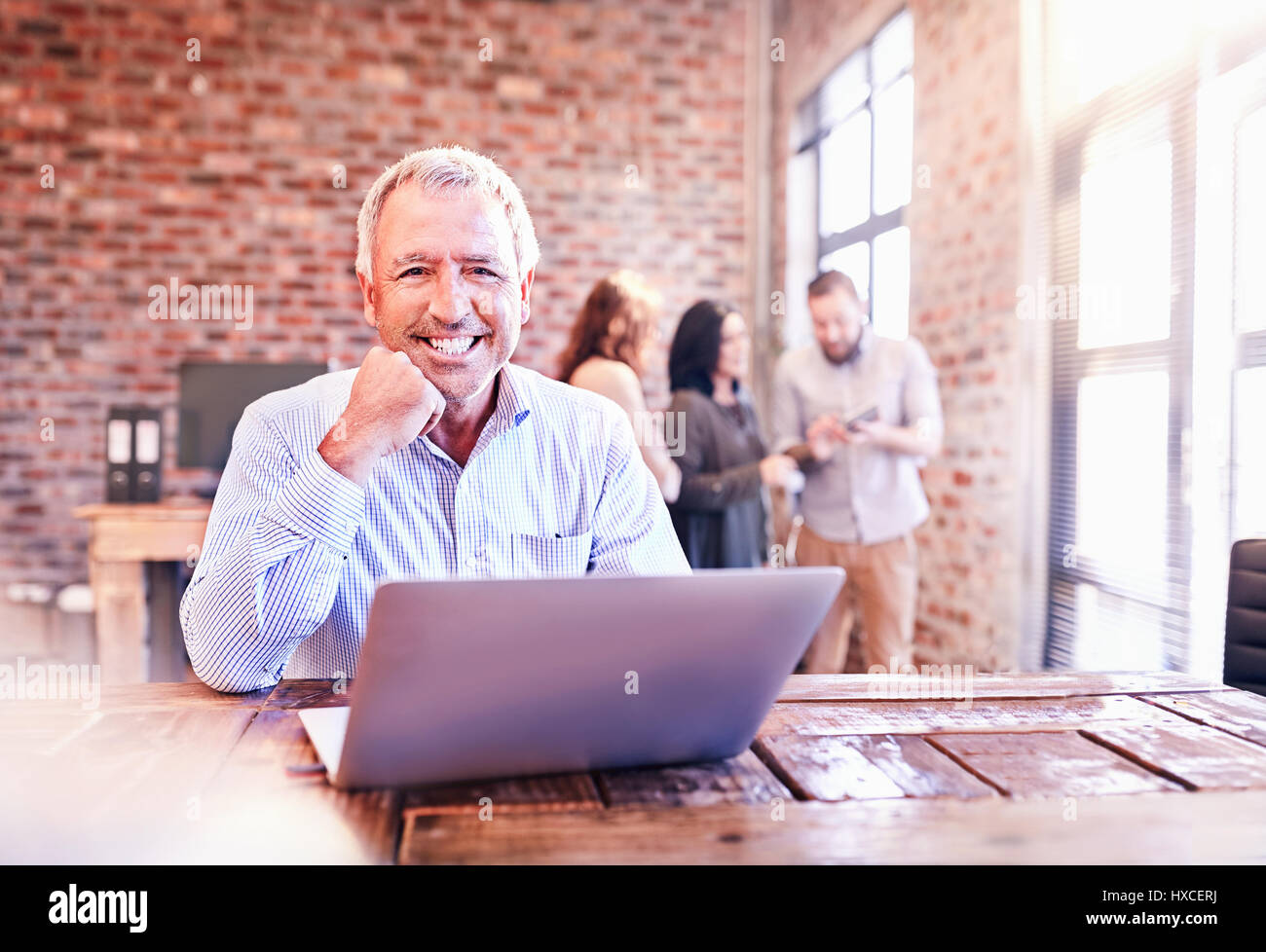 Ritratto sorridente imprenditore lavora al computer portatile Foto Stock