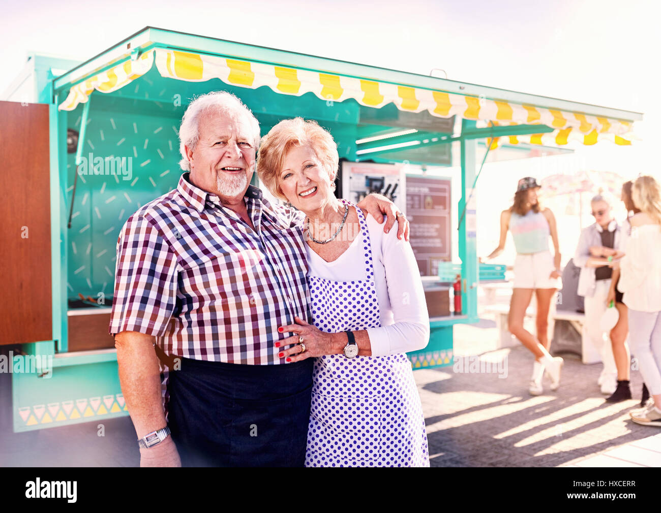 Ritratto sorridente senior business proprietari al di fuori di sunny food cart Foto Stock