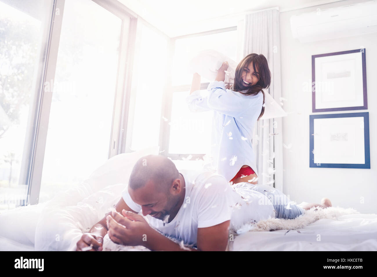 Giocoso giovane cuscino combattimenti in camera da letto Foto Stock