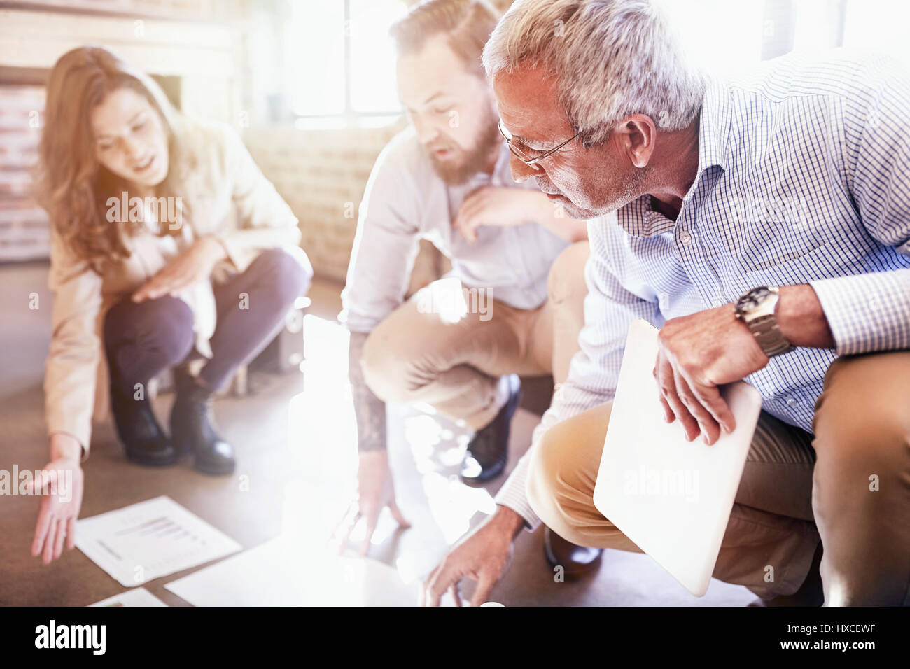 La gente di affari esaminando e discutendo la documentazione sulle sole ufficio piano Foto Stock