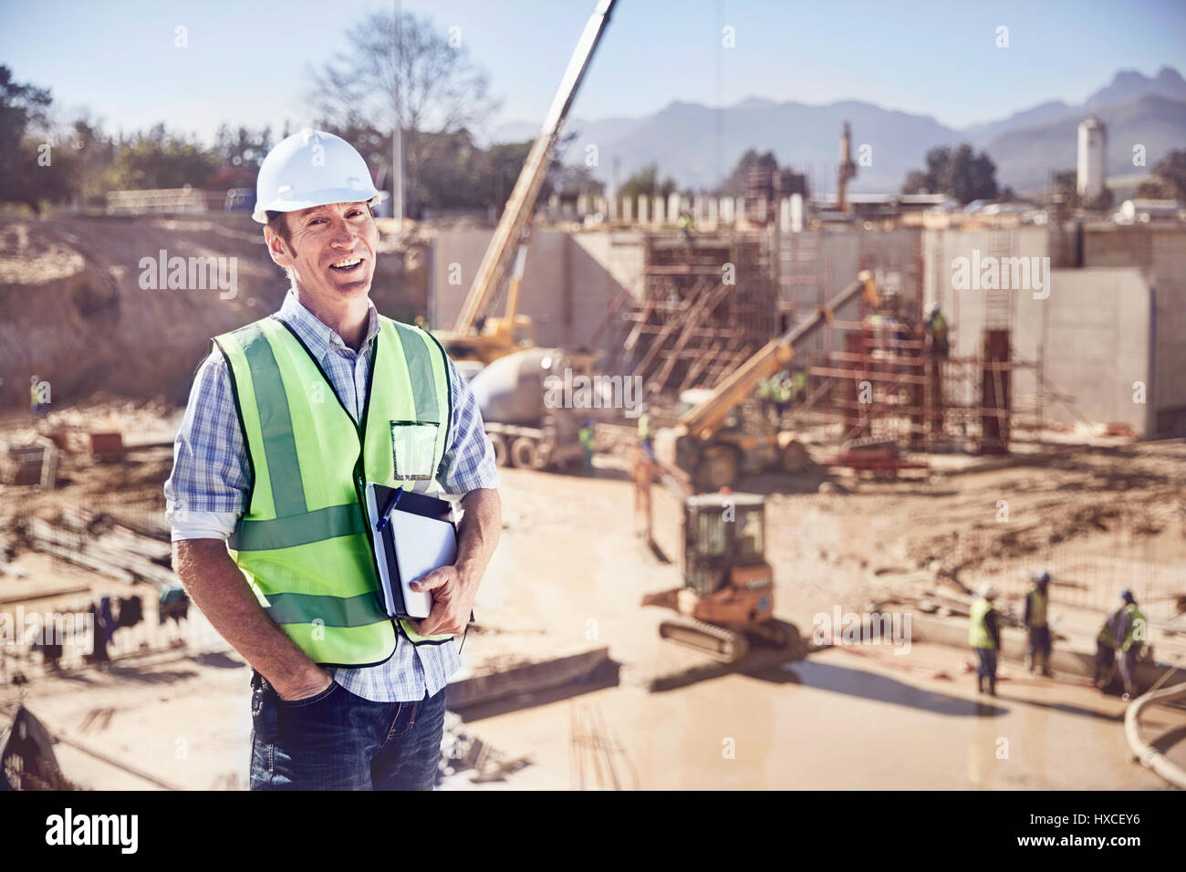 Ritratto fiducioso operaio edile foreman a sunny sito in costruzione Foto Stock