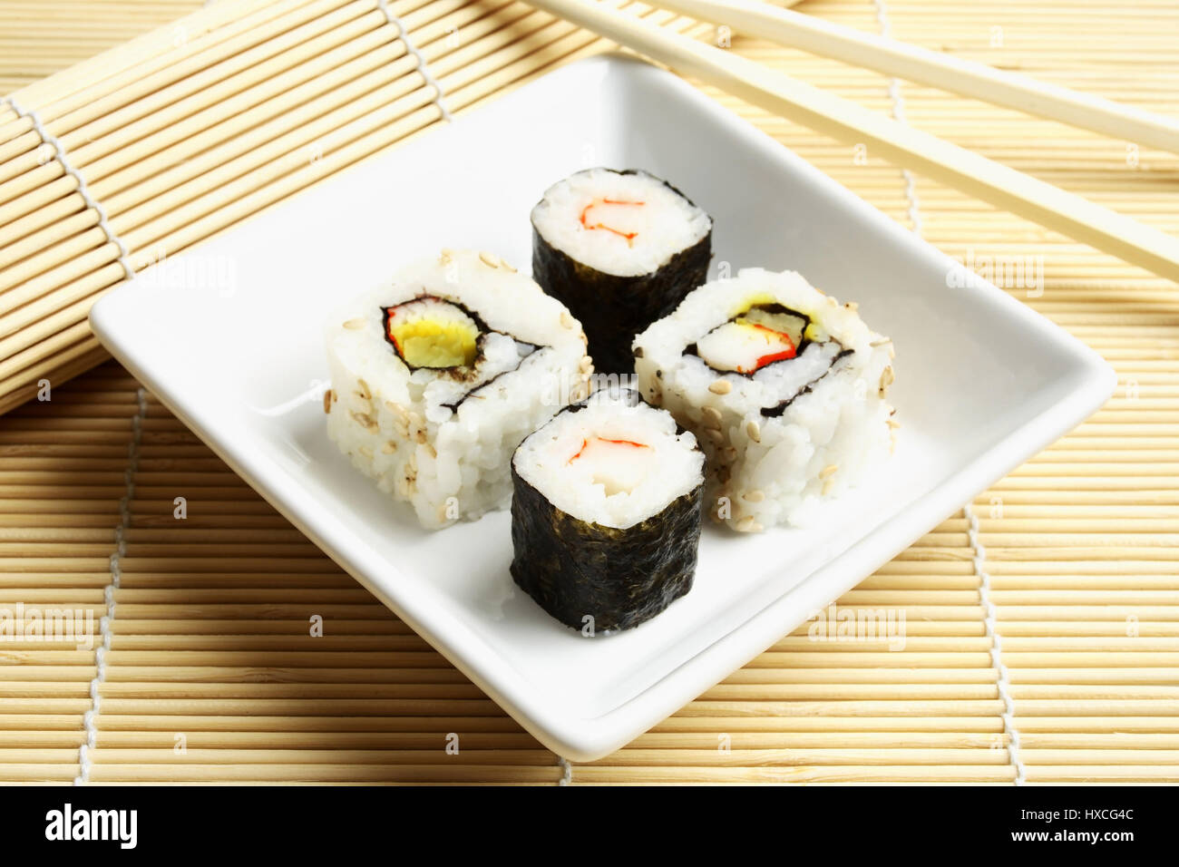 Il Sushi con baguette e tappetino di bambù, Sushi mit Essstaebchen und Bambusmatte Foto Stock