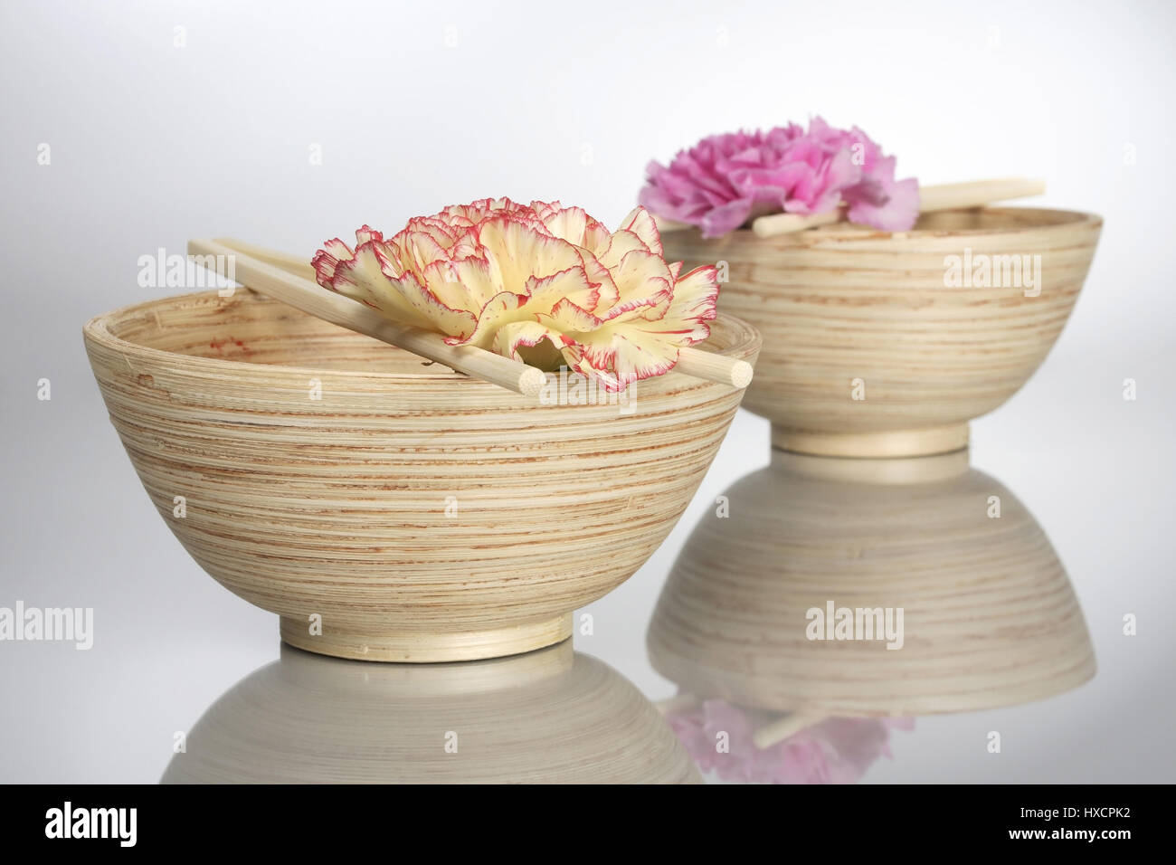 Ciotole di legno con asta e fiori di garofano, Holzschalen mit Staebchen und Nelkenblueten Foto Stock