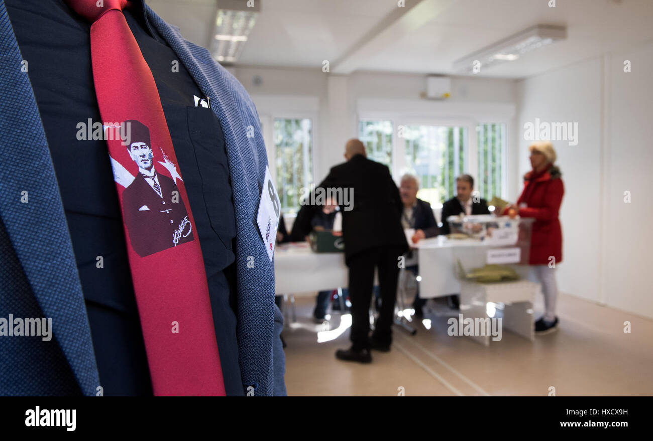 Berlino, Germania. 27 Mar, 2017. Un uomo con la foto di Kemal Attaturk sul suo cravat può essere visto in corrispondenza di una stazione di polling presso l'ambasciata turca a Berlino, Germania, 27 marzo 2017. Sullo sfondo di un uomo è la fusione il suo voto. La gente turca in Germania sono chiamati a votare nel controverso piano di riforma del presidente turco Erdogan. La riforma avrebbe concesso il capo di stato di una significativa quantità di potenza in Turchia. Foto: Bernd von Jutrczenka/dpa/Alamy Live News Foto Stock