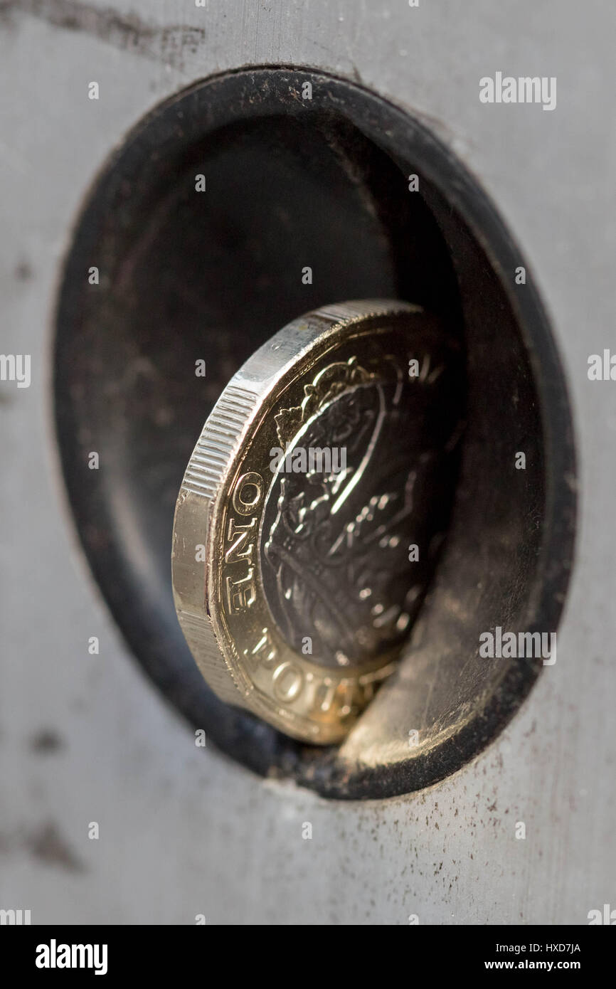 Londra, Regno Unito. 28 Mar, 2017. Nuovo £ 1 monete di entrare in circolazione, che sostituisce il vecchio cancelletto. L'introduzione della moneta ha significato carrelli per supermercati, parcheggio auto metri(qui presentati) e distributori automatici hanno dovuto essere convertite. 12 facciate e che presenta elevate caratteristiche di sicurezza, la nuova bi-moneta metallica è realizzata in due diverse leghe composto di rame, zinco e nichel. L'anello esterno è placcato in ottone mentre il cerchio interno è placcato in nichel. Credito: Guy Corbishley/Alamy Live News Foto Stock