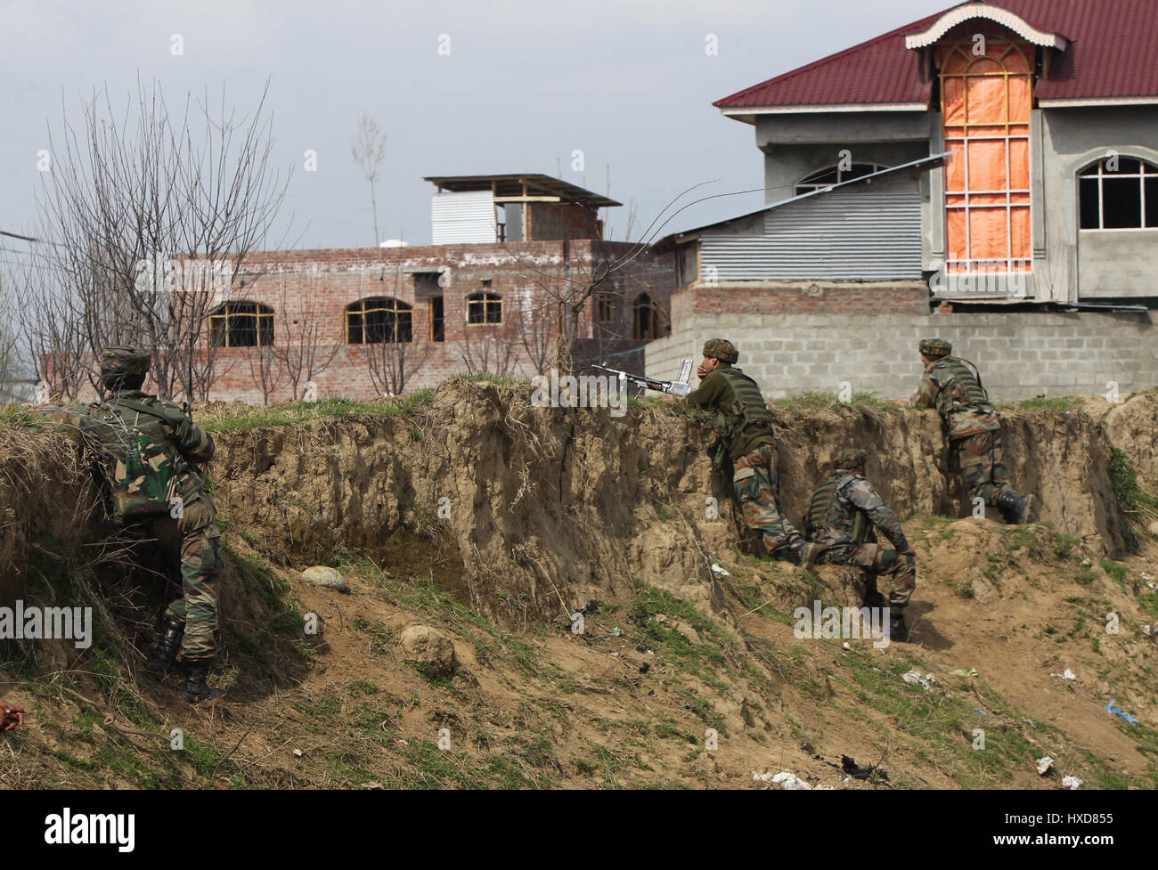 Srinagar Kashmir. 28 Mar, 2017. Esercito indiano troopers prendere posizione durante uno scontro a fuoco nel villaggio di Durbugh Chadoora del distretto di Budgam, circa 22 km a sud di Srinagar city, la capitale estiva del Kashmir, 28 marzo 2017. Almeno tre giovani sono stati uccisi e 13 altri feriti martedì dopo le forze governative hanno sparato su manifestanti in prossimità di un gunfight sito nella irrequieta Kashmir, la polizia ha detto. Credito: Javed Dar/Xinhua/Alamy Live News Foto Stock