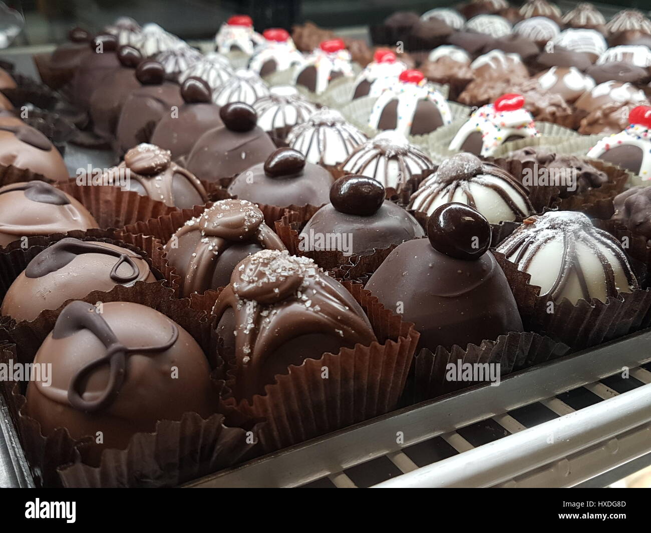 Un assortimento di tartufi di cioccolato Dessert allineate in un panificio display Foto Stock