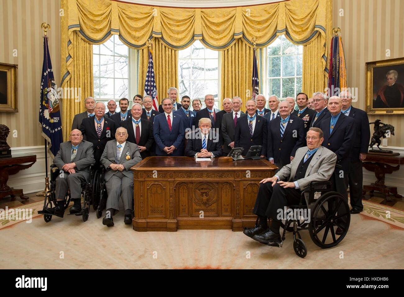 U.S presidente Donald Trump in posa per una foto di gruppo con Medal of Honor i destinatari circa la risoluta scrivania in ufficio Ovale della Casa Bianca Marzo 24, 2017 a Washington, DC. In piedi intorno al presidente sono il segretario della Veterans Affairs Dr David Shulkin, sinistra, Segretario della Difesa James Mattis, centro e Vice Presidente Mike Pence, destra. Foto Stock