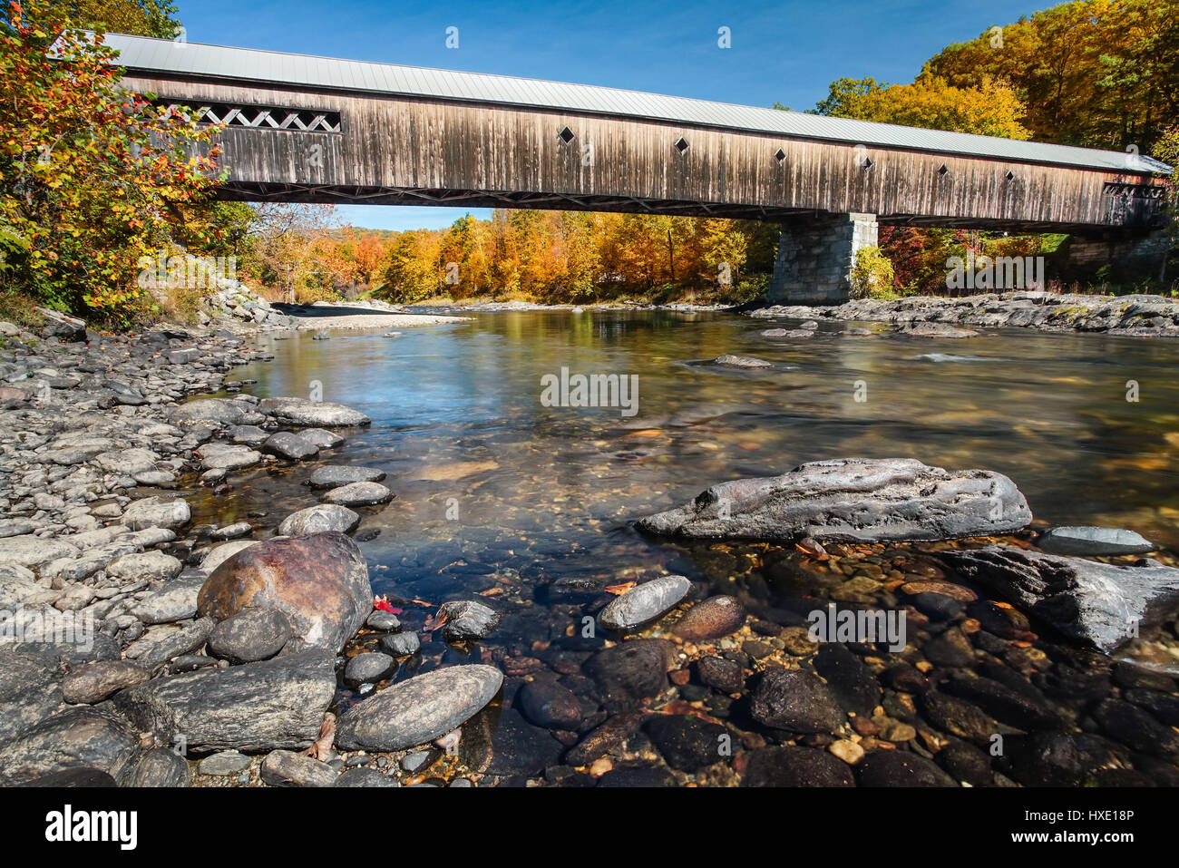 Colore Autunm presso il West Dummerston ponte coperto oltre il fiume ad ovest in Dummerston, Vermont. Foto Stock