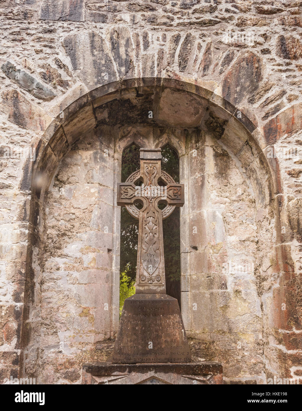Croce celtica nell'arcata delle rovine di un castello in Irlanda Foto Stock