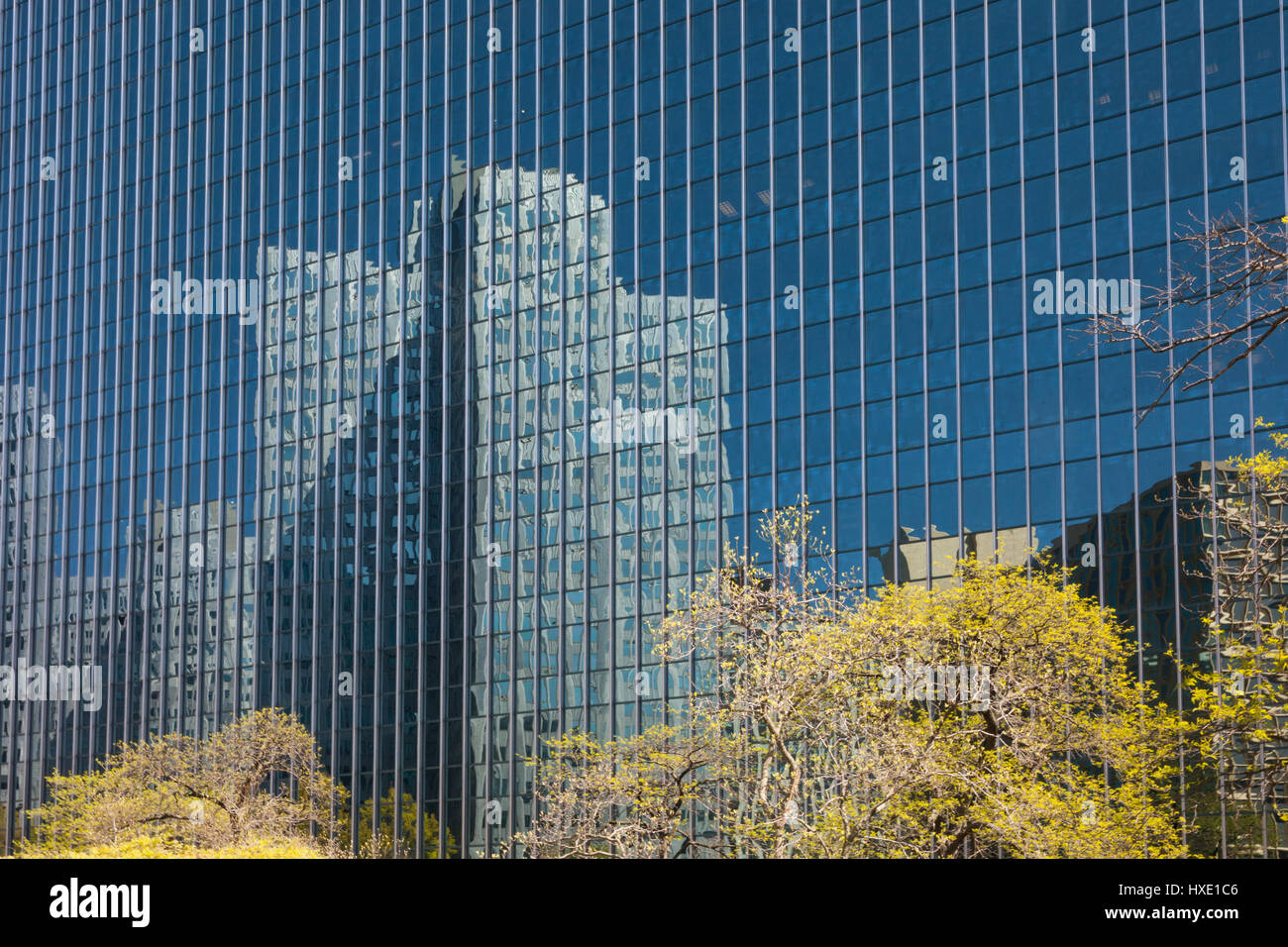 La riflessione di un edificio sulla facciata di vetro di un edificio. Foto Stock