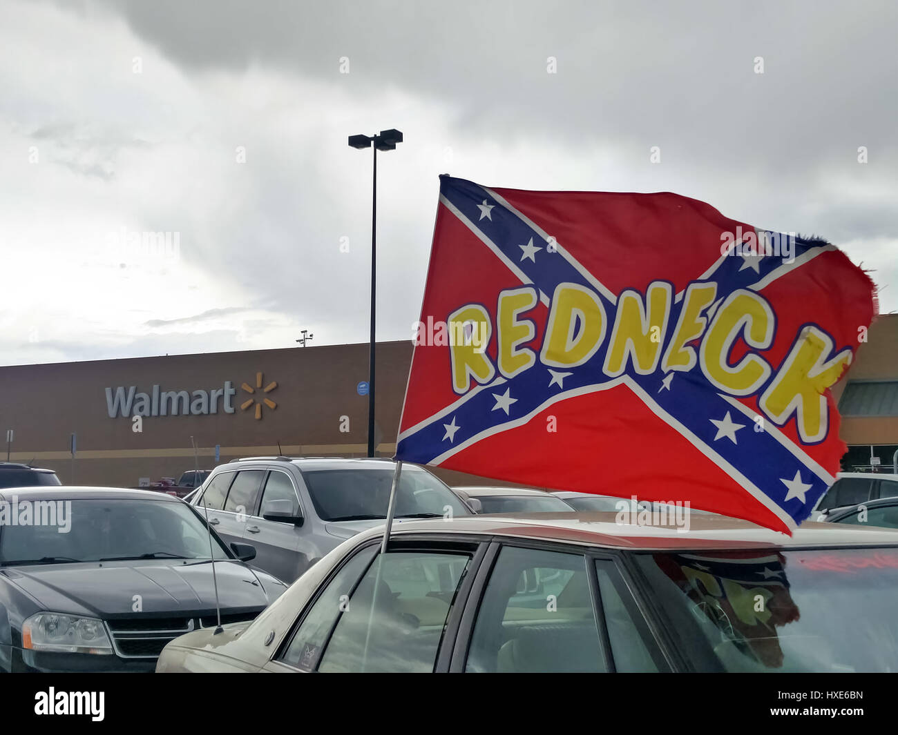 Un confederato bandiera con la parola "dneck' scritto su di esso vola su una macchina parcheggiata in un Walmart parcheggio . Foto Stock