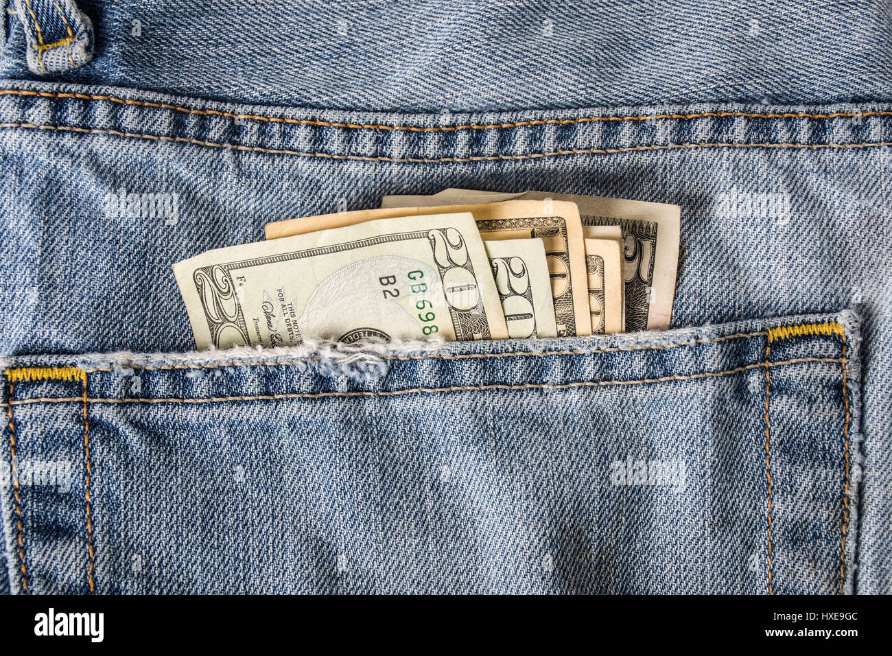 Una tasca posteriore dei jeans blu che mostra il denaro americano ventaglio. Foto Stock