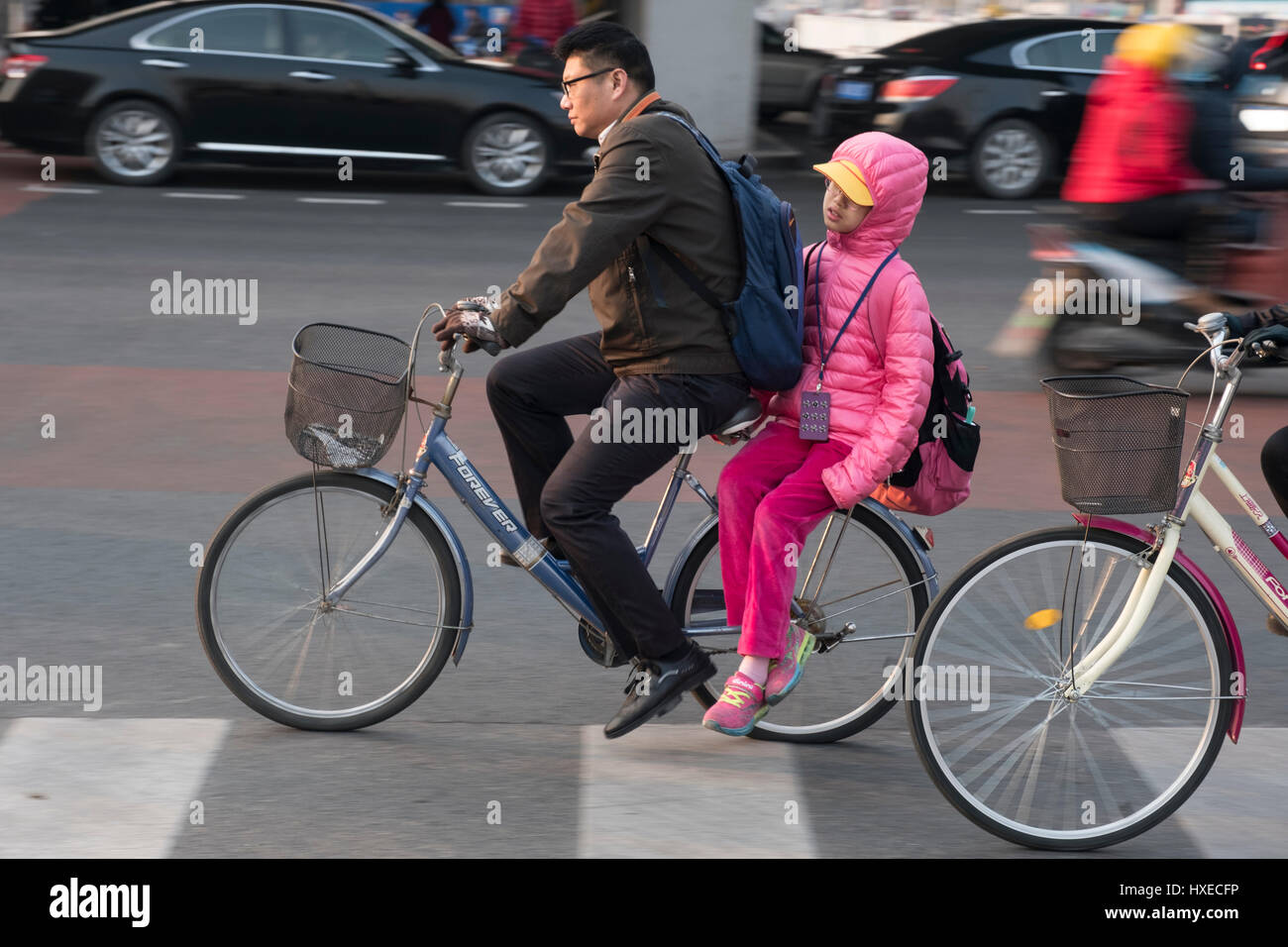 Un padre cinese prende la sua ragazza sulla sua moto a scuola di mattina a Pechino in Cina. 28-Mar-2017 Foto Stock