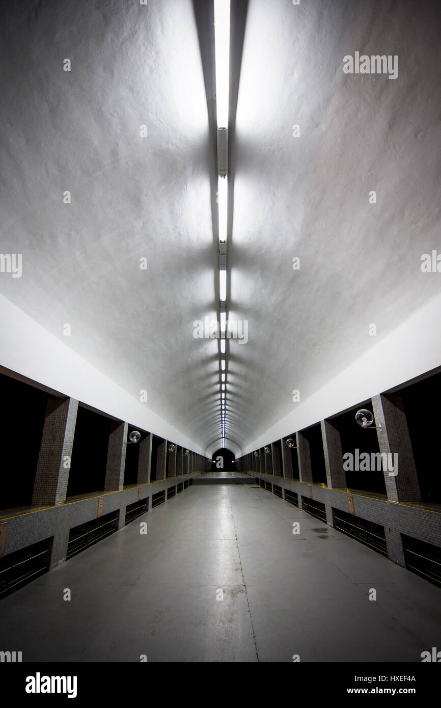 Un lungo coperto illuminato cammino tunnel che conduce lontano da Brunei la più grande moschea. Di Jame Asr Hassanil Bolkiah moschea. Foto Stock