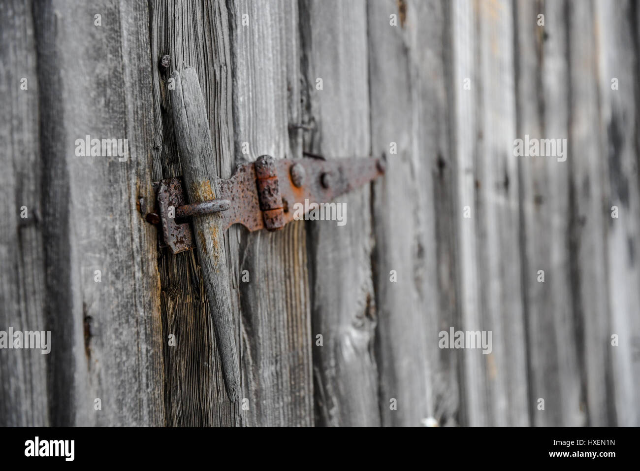 Un arrugginito fermo su un vecchio capannone in legno porta Foto Stock