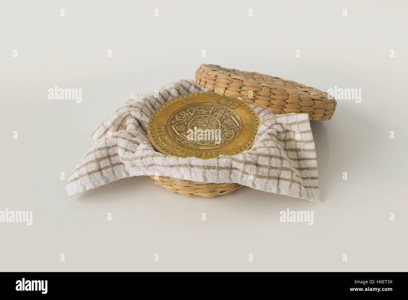 Dieci pesos messicani moneta all'interno di un cestello di frittata di patate Foto Stock