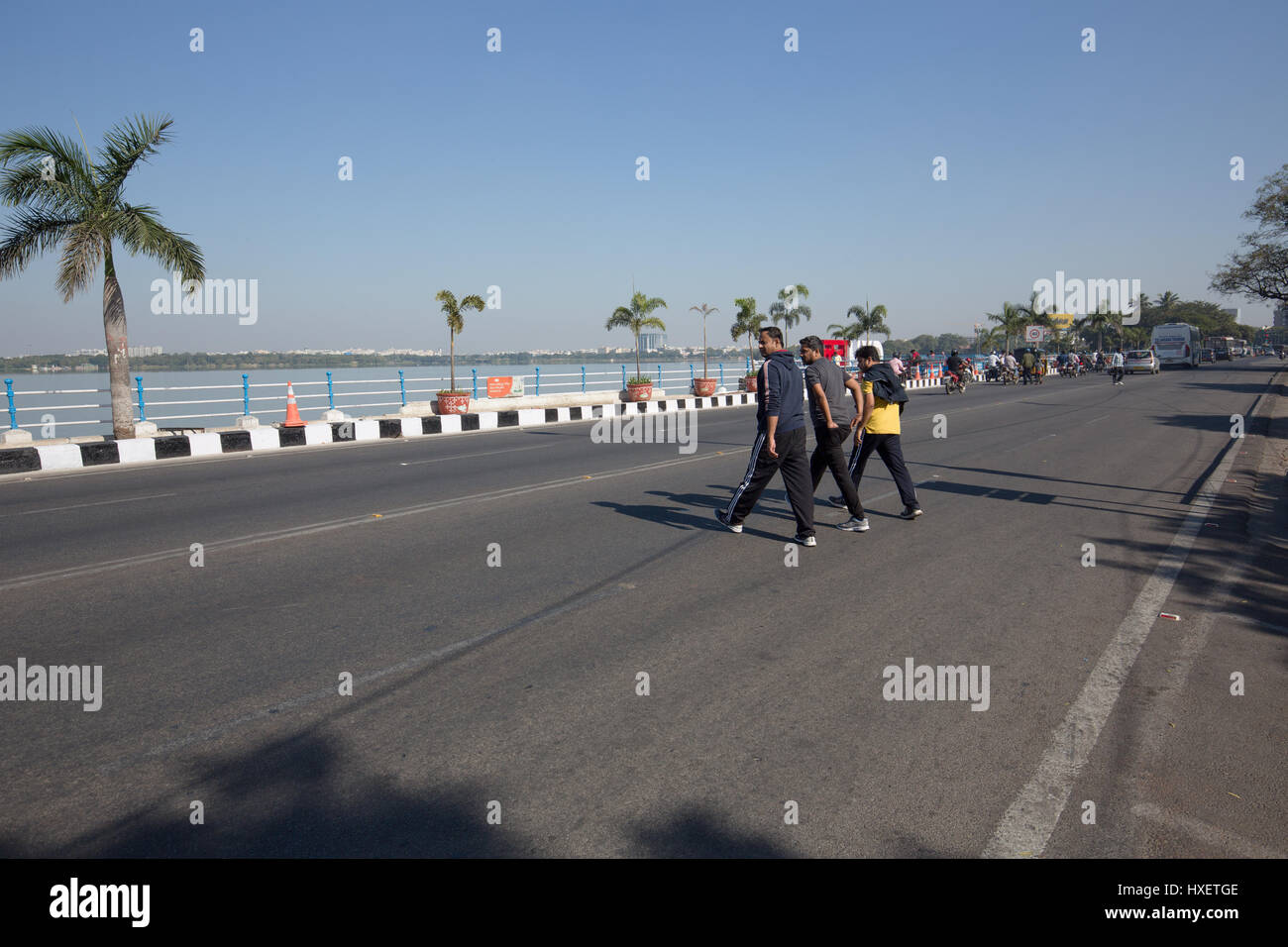 Hyderabad, India - novembre 26,2016. tre uomini attraversare la strada sulla strada tanbund vicino amore hyderabad sculpture.amore hyd è una nuova installazione tipografica Foto Stock