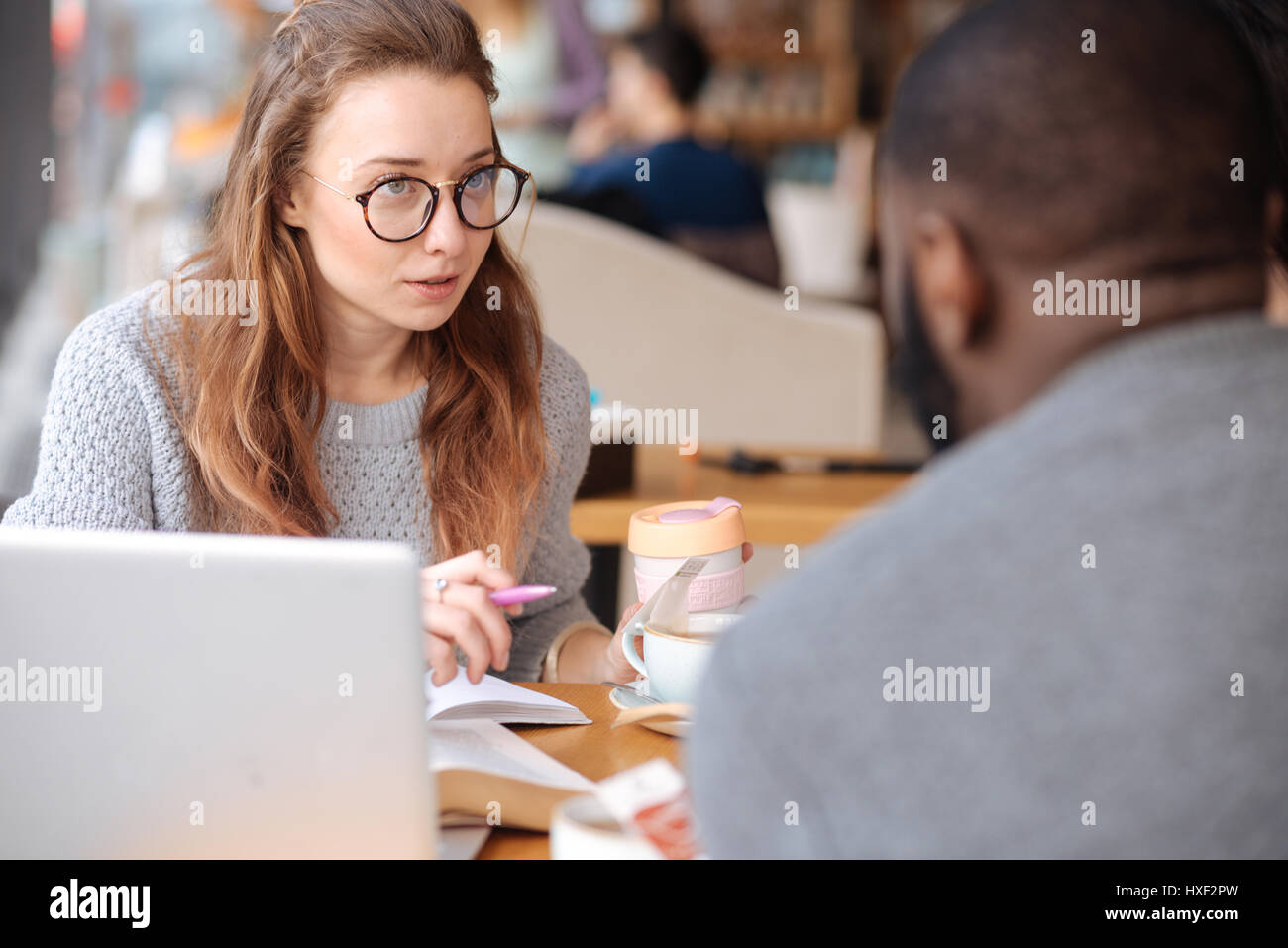 Piacevole giovane donna a discutere di studiare i problemi Foto Stock