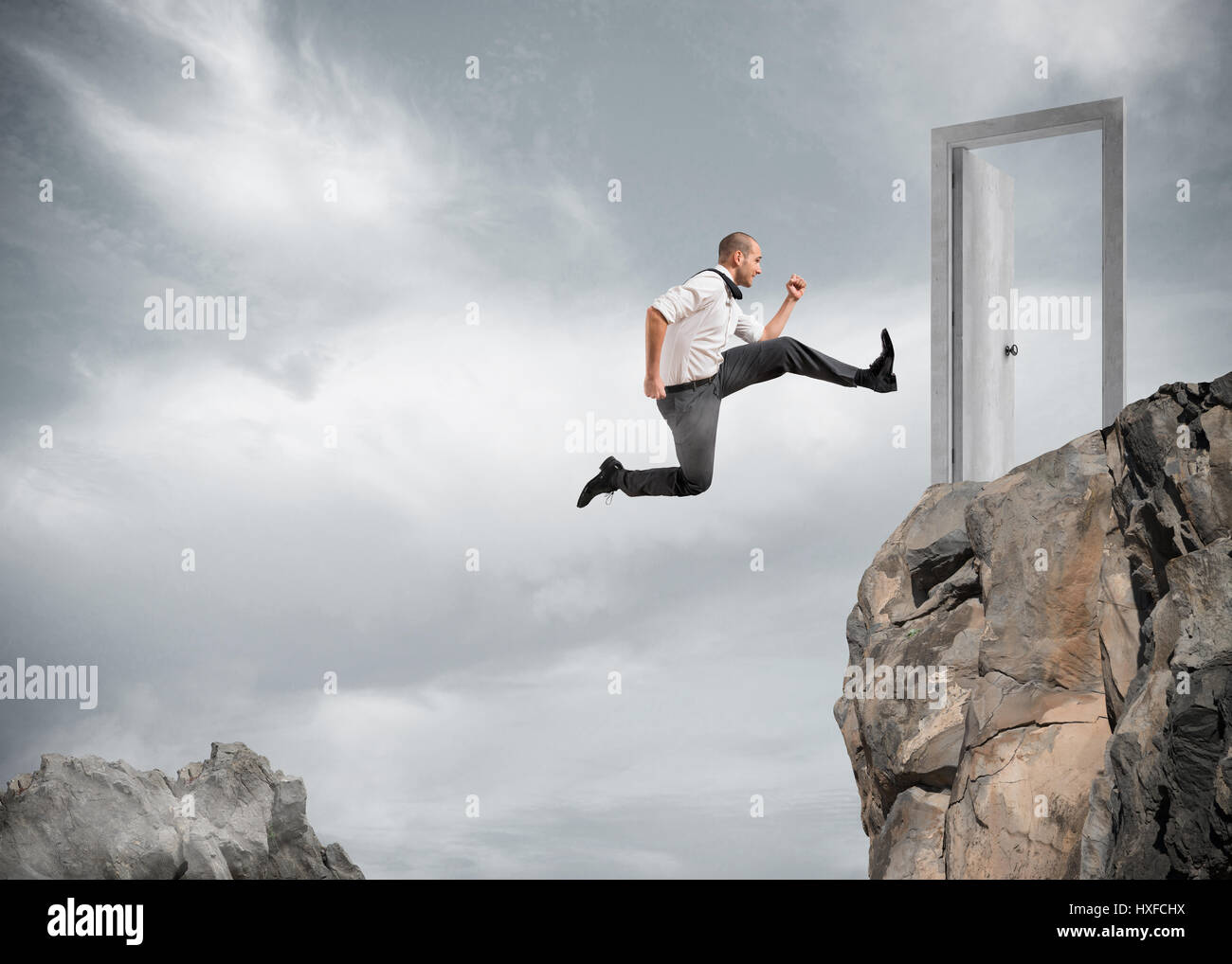 Imprenditore saltando le montagne per raggiungere una porta Foto Stock