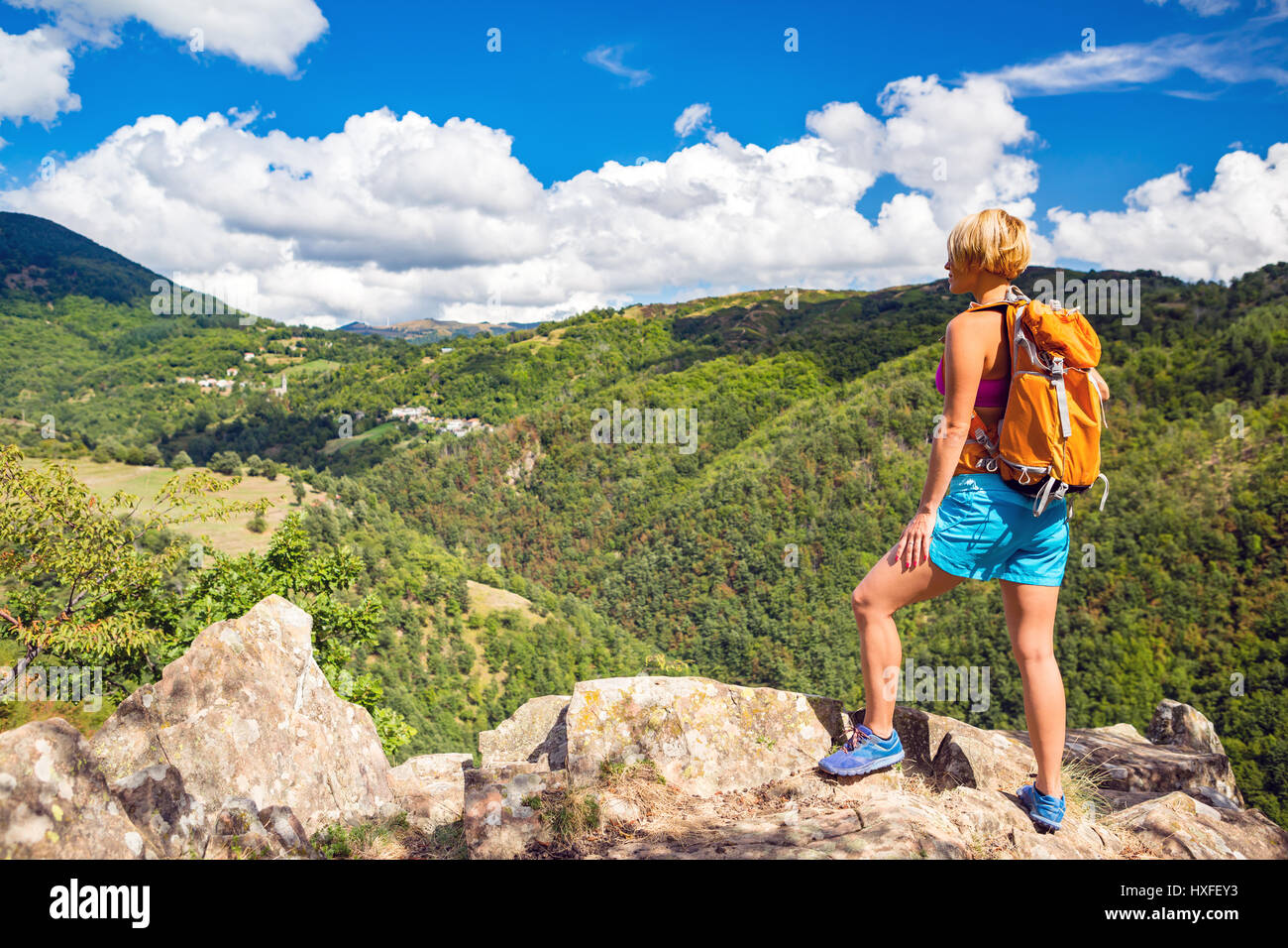 Escursionismo donna guardando ispiranti Montagne Paesaggio. Fitness e uno stile di vita sano all'aperto in una colorata estate natura. Trekking, camping e cli Foto Stock
