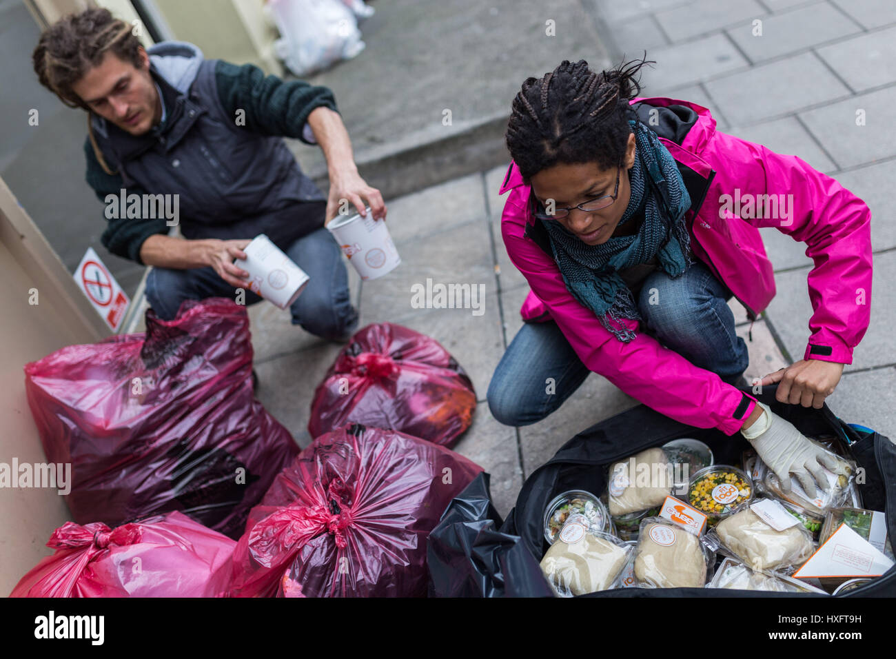 2 occupanti abusivi sono la raccolta di cibo gratuito oggetto di pratiche di dumping da parte di un ristorante locale Foto Stock