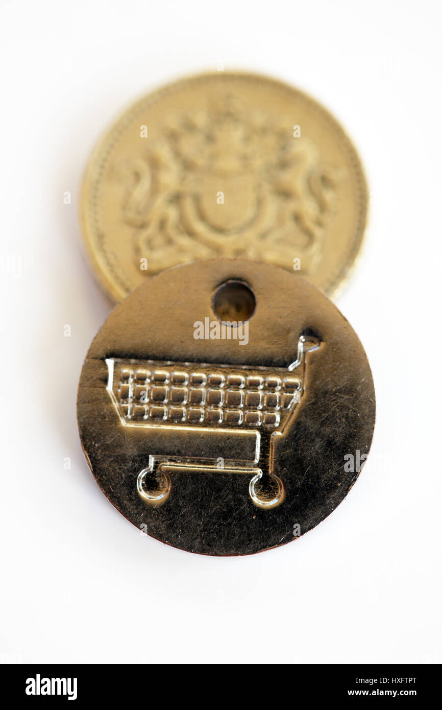 Una libbra di monete e di una stessa dimensione carrello del supermercato token. Un nuovo Regno Unito £ 1 moneta è stata introdotta il 28 marzo 2017 con la vecchia lira in fase di graduale eliminazione. Foto Stock