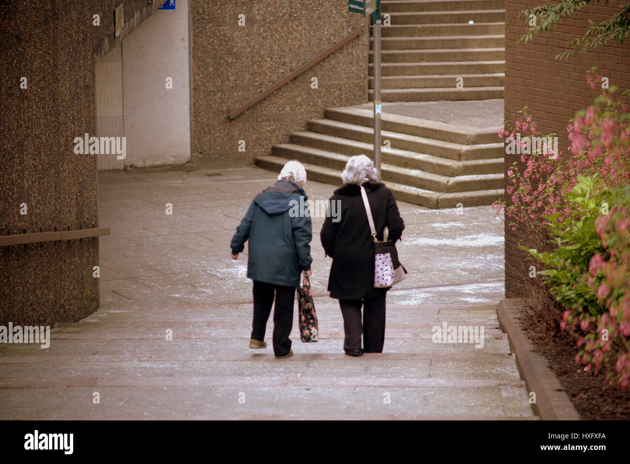 Paesaggio urbano individuale due donne anziane da solo a piedi Foto Stock