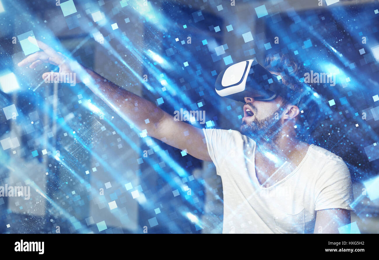 Giovane Uomo con occhiali VR riproduzione di realtà virtuale toccando blue square poligoni Foto Stock