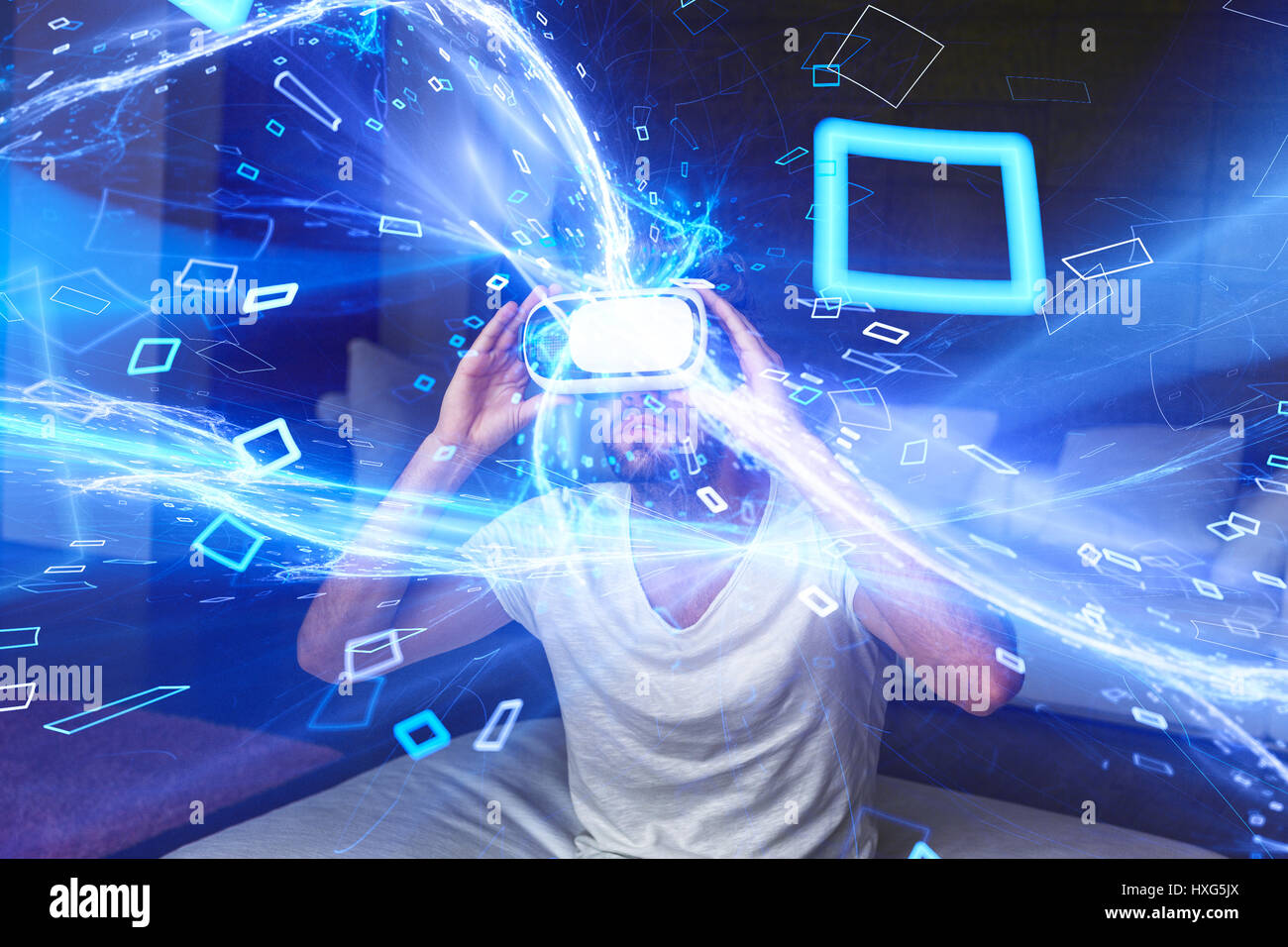 Giovane Uomo con cuffie riproduzione di realtà virtuale con blu brillante streaming multimediale e particelle Foto Stock