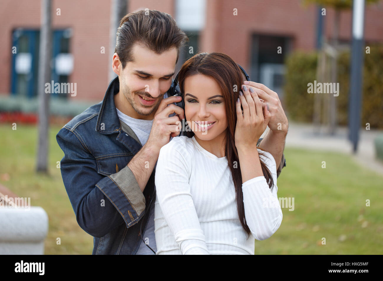 Felice giovane coppia caucasica ascoltare musica all'aperto Foto Stock