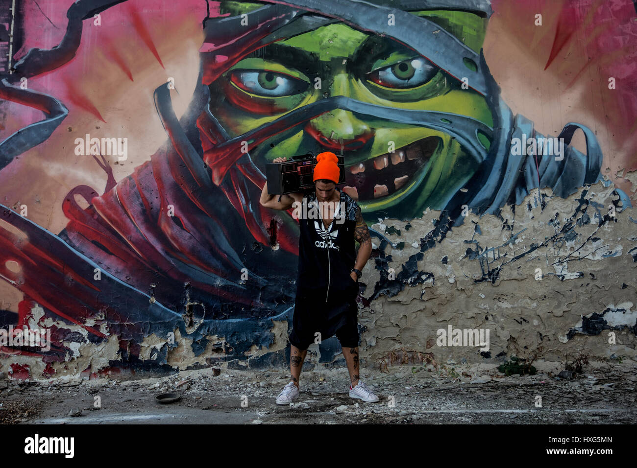 Atleta è in piedi di fronte a un dipinto murale di graffiti Foto Stock