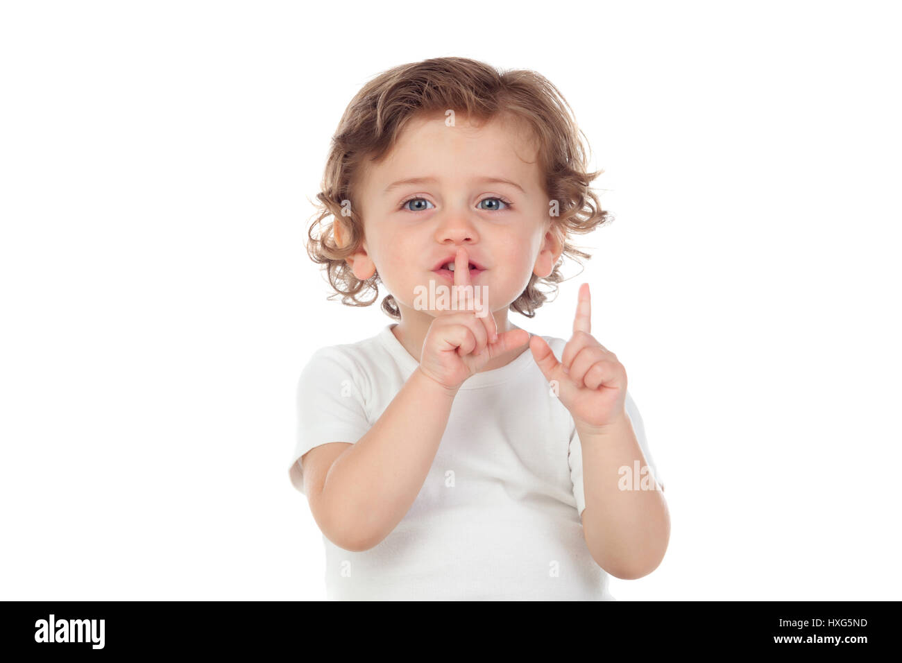 Carino baby ha messo l'indice per labbra come segno di silenzio, isolato su sfondo bianco Foto Stock