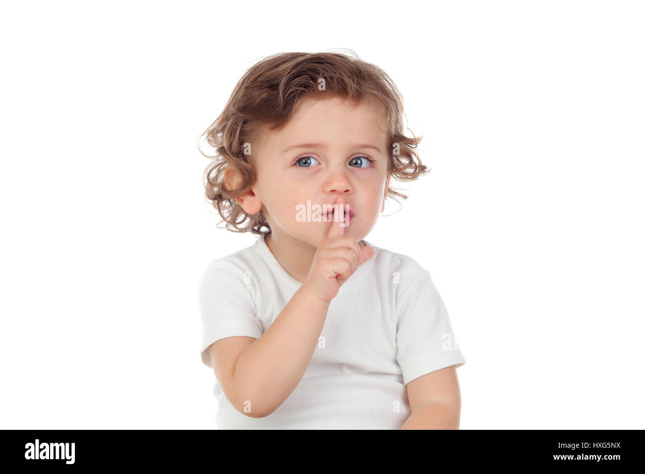 Carino baby ha messo l'indice per labbra come segno di silenzio, isolato su sfondo bianco Foto Stock